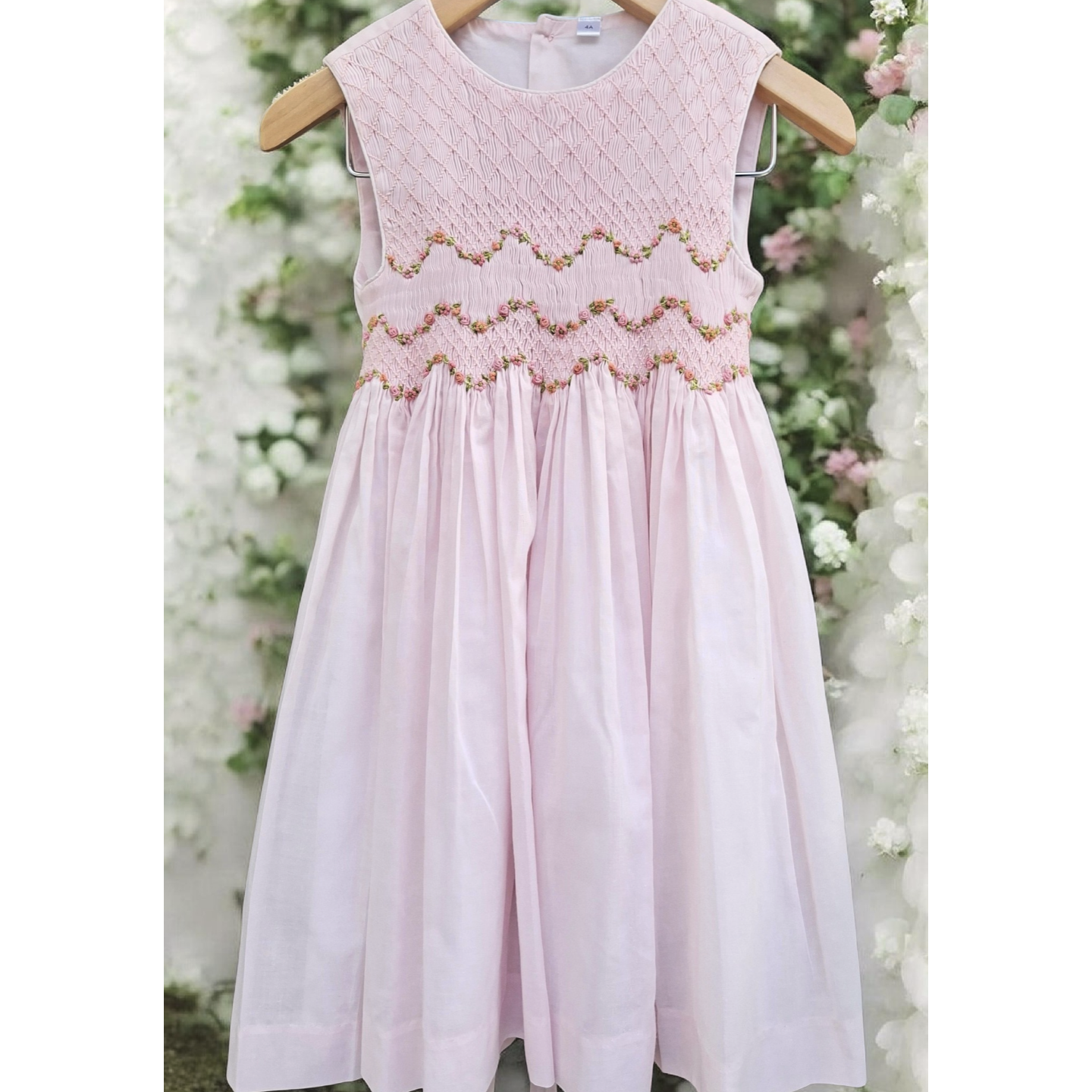 Robe de cérémonie fille rose pastel, smockée à la main et détails floraux raffinés.