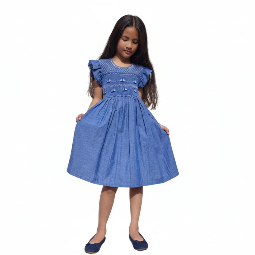 Robe à smocks bleu chambray motif bateaux avec petites manches volantes. Robe fille estivale.